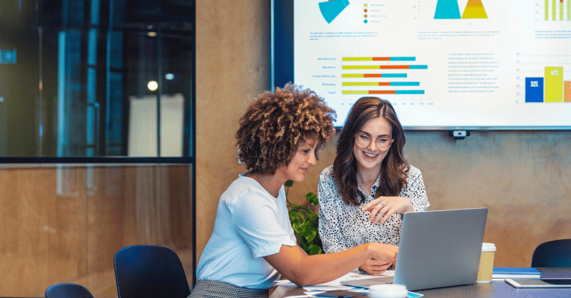 Two female leaders reviewing employee data from recent assessment activities.